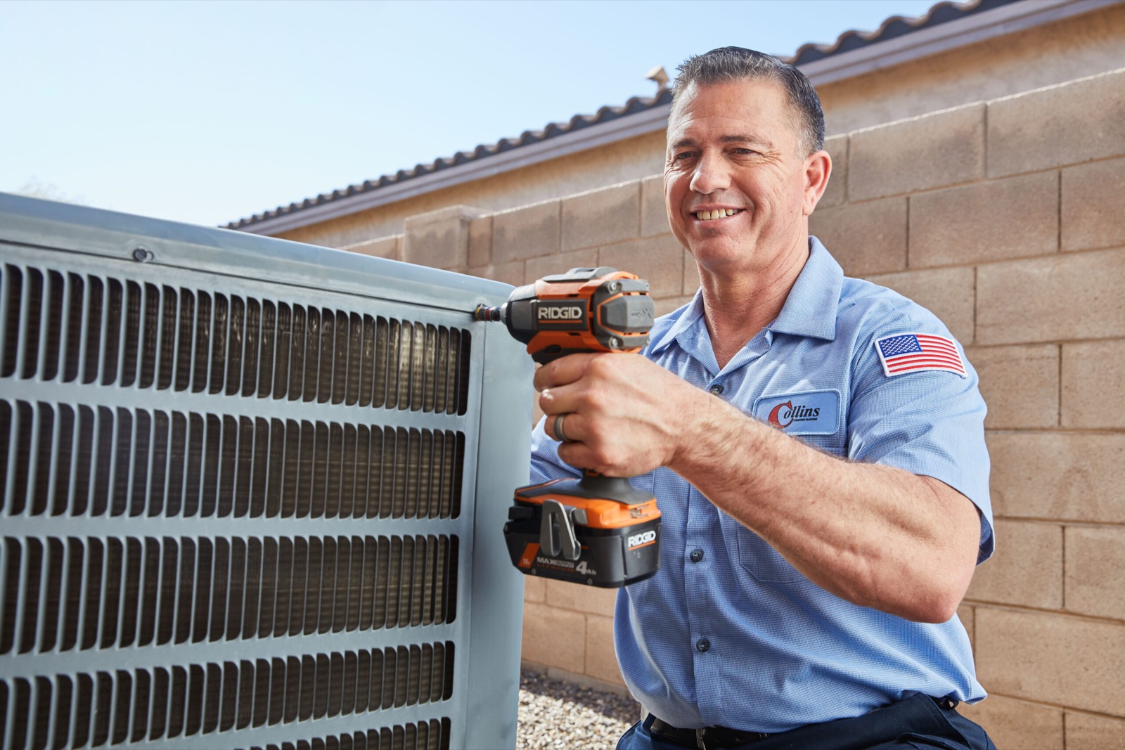 A Wrench Group technician servicing an outdoor air-conditioning condenser unit
