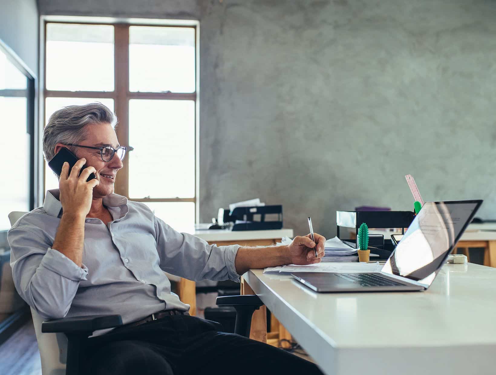 business-man-on-phone-at-desk-1640x1240